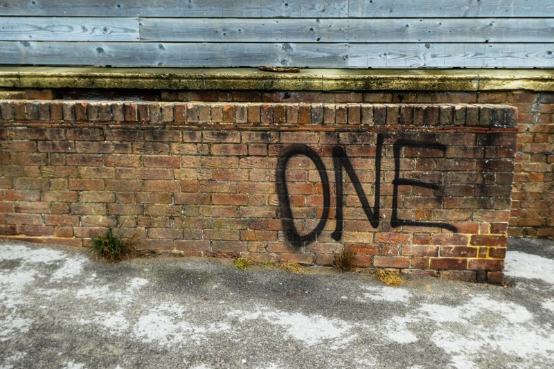 壁にスプレーされた「one」の文字